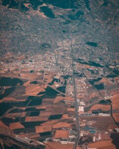Aerial view showcasing a blend of urban sprawl and farmlands. Clear division of city and agriculture.
